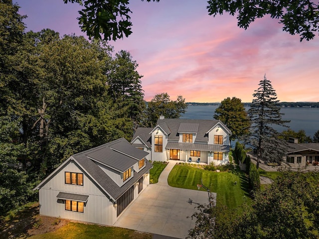 view of front facade featuring a garage, a lawn, and a water view