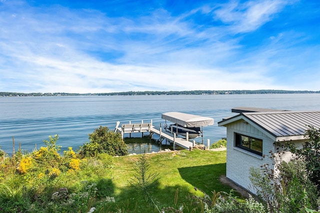 dock area with a water view and a lawn