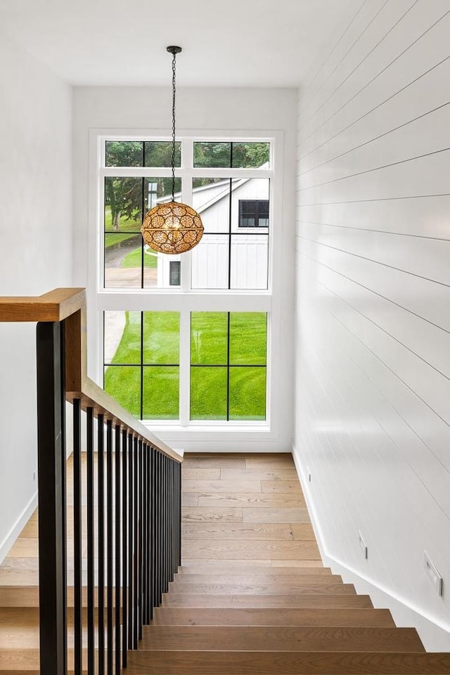 stairway featuring hardwood / wood-style flooring and a healthy amount of sunlight