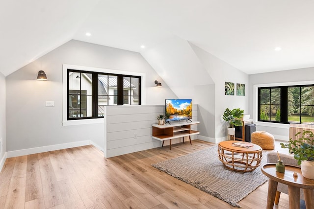 living area featuring vaulted ceiling and light hardwood / wood-style floors