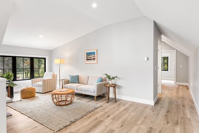 living room with vaulted ceiling and light wood-type flooring