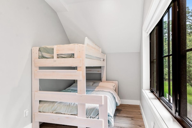 bedroom featuring hardwood / wood-style flooring and vaulted ceiling