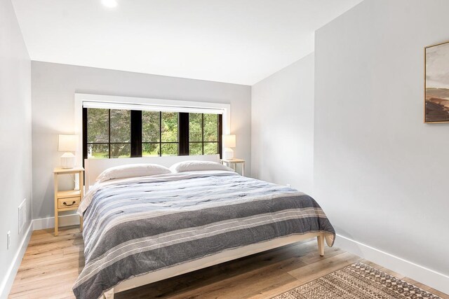 bedroom featuring lofted ceiling and light hardwood / wood-style flooring