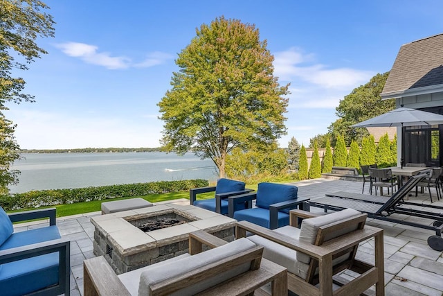 view of patio featuring an outdoor living space with a fire pit and a water view