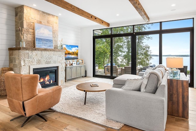 living room with plenty of natural light, wood walls, a fireplace, and light hardwood / wood-style flooring