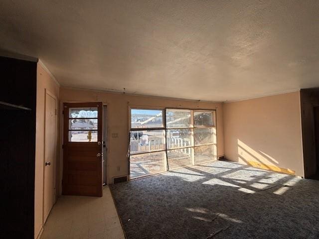 doorway with a textured ceiling and visible vents