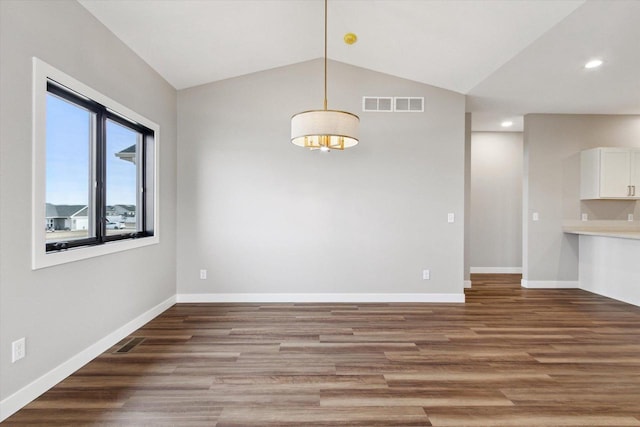 spare room with hardwood / wood-style flooring and vaulted ceiling