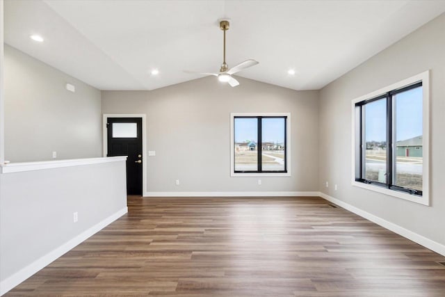 unfurnished room featuring lofted ceiling, ceiling fan, wood-type flooring, and a healthy amount of sunlight