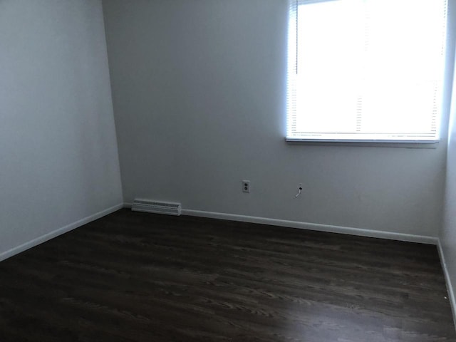 unfurnished room with dark wood-type flooring