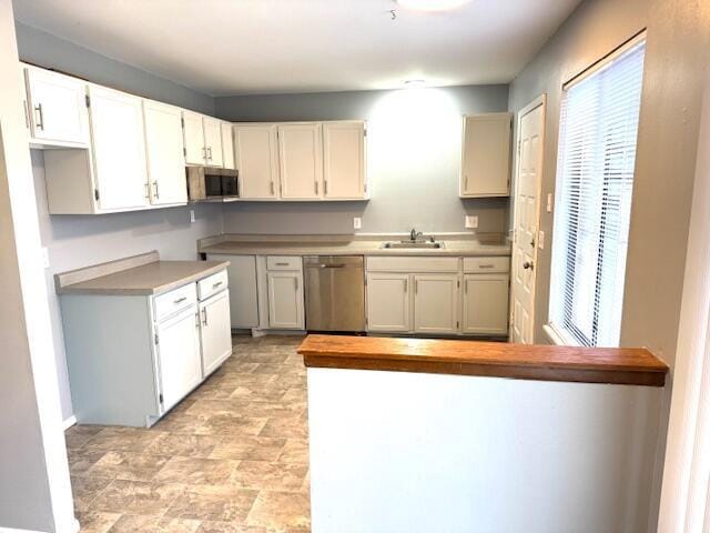 kitchen with appliances with stainless steel finishes, sink, and white cabinets