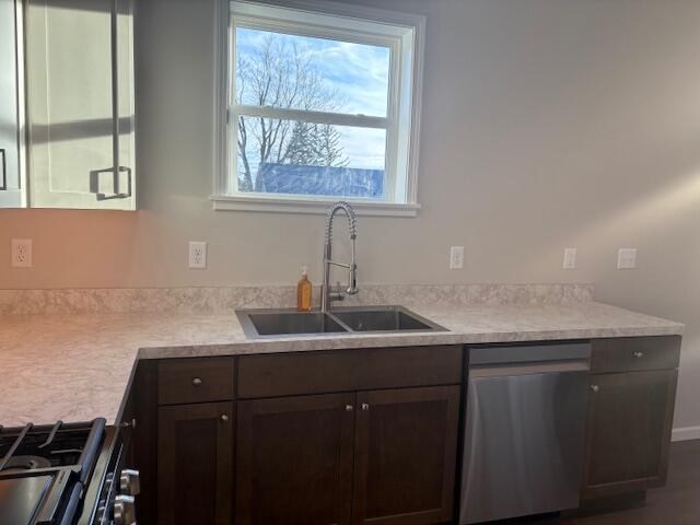 kitchen featuring gas stove, stainless steel dishwasher, sink, and dark brown cabinets