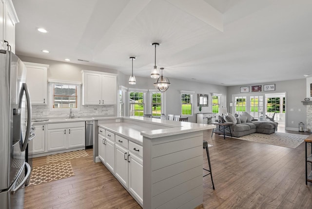 kitchen featuring white cabinetry, stainless steel fridge, and a breakfast bar