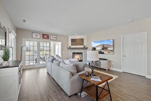 living room featuring hardwood / wood-style flooring, a fireplace, and french doors