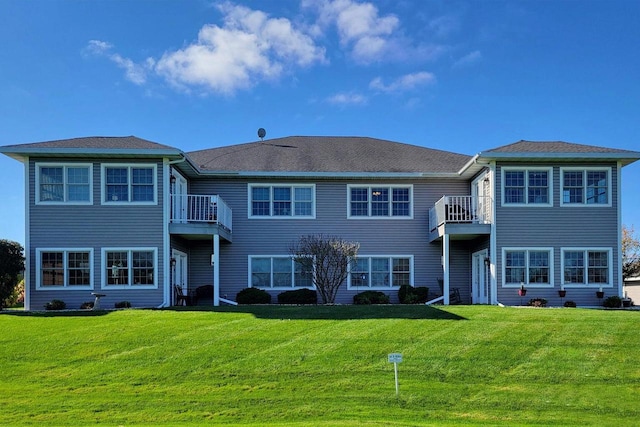 view of front of house featuring a front yard and a balcony