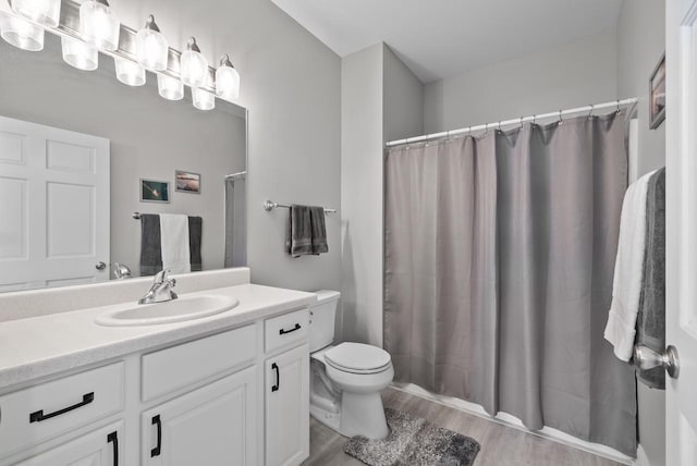 bathroom with vanity, toilet, and wood-type flooring