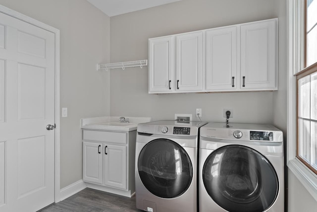 laundry area with cabinets, dark hardwood / wood-style flooring, a wealth of natural light, and washer and clothes dryer