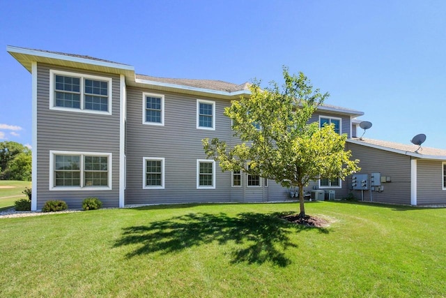 rear view of property featuring a yard and central AC unit