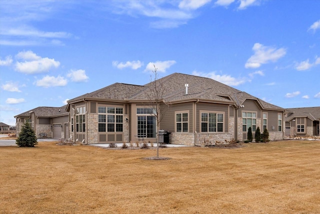 back of property with a garage and a lawn