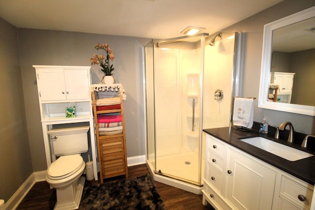 bathroom with an enclosed shower, vanity, hardwood / wood-style flooring, and toilet