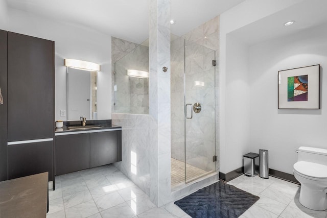 bathroom with vanity, a shower with door, and toilet