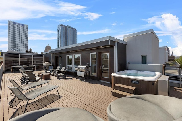 deck with grilling area and a hot tub