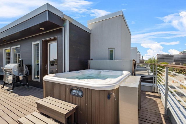 wooden deck featuring a hot tub and a grill