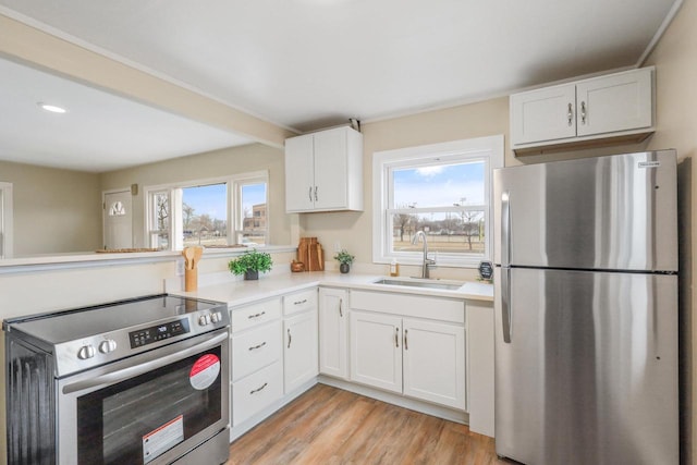 kitchen featuring white cabinetry, appliances with stainless steel finishes, sink, and a wealth of natural light