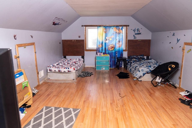 bedroom with wood-type flooring and vaulted ceiling