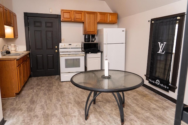 kitchen featuring lofted ceiling, sink, and white appliances