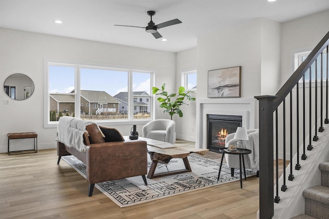 living room with ceiling fan and light hardwood / wood-style flooring