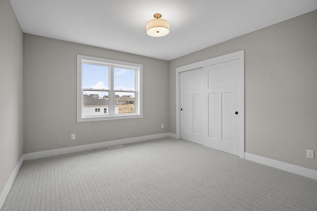 unfurnished bedroom featuring carpet and a closet