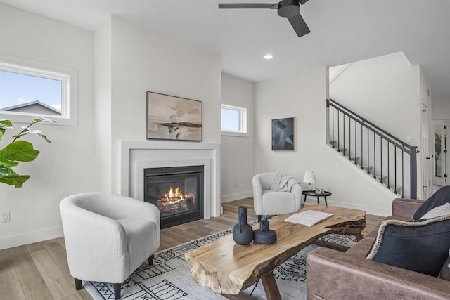 living room with ceiling fan and light hardwood / wood-style flooring