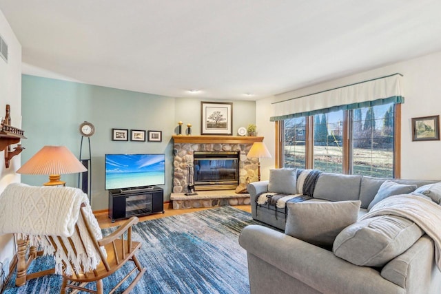 living room featuring a stone fireplace and hardwood / wood-style flooring