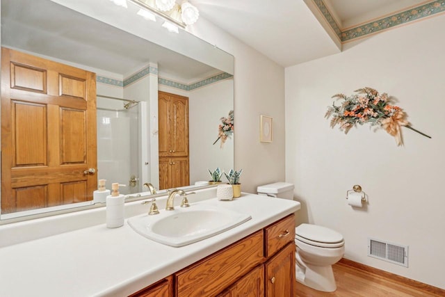 bathroom with vanity, hardwood / wood-style floors, toilet, and a shower