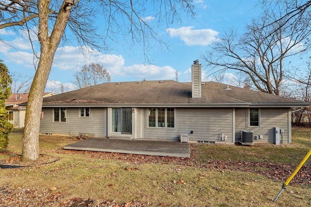 rear view of house featuring cooling unit and a lawn