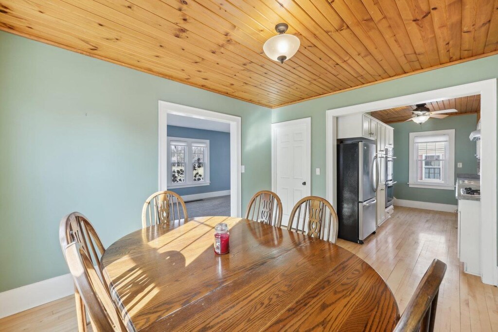 dining area with wood ceiling and light hardwood / wood-style flooring