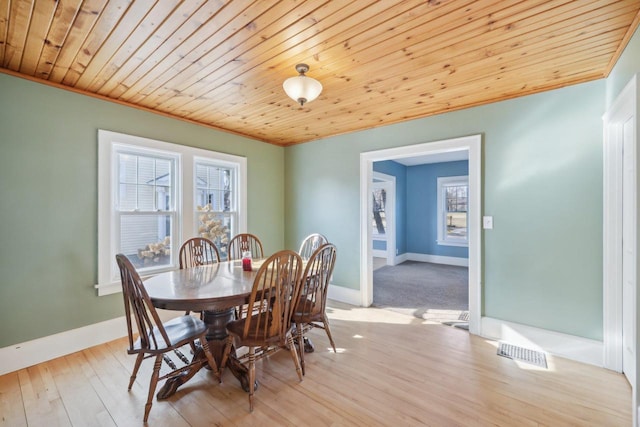 dining room featuring crown molding, light hardwood / wood-style flooring, and wooden ceiling