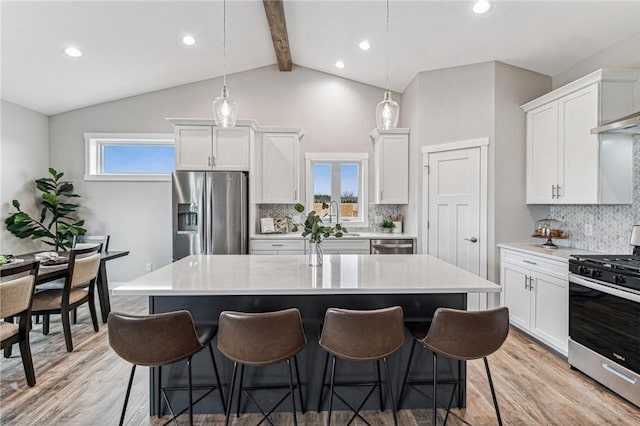 kitchen with stainless steel appliances, a center island, and pendant lighting