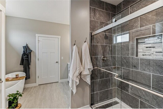 bathroom with hardwood / wood-style flooring and shower with separate bathtub