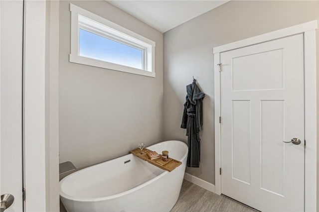 bathroom featuring a tub to relax in and wood-type flooring