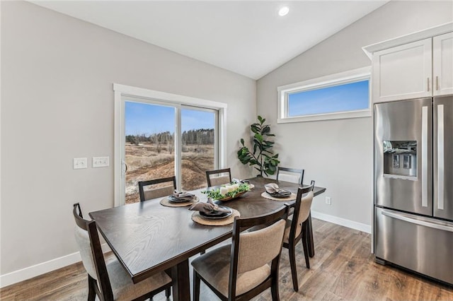 dining area featuring lofted ceiling and hardwood / wood-style flooring