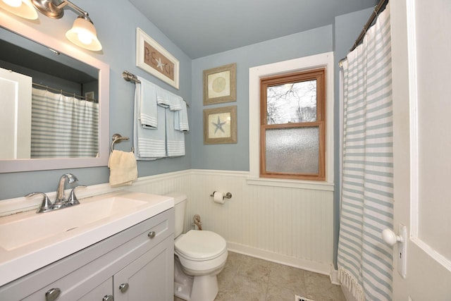 bathroom featuring vanity, tile patterned floors, and toilet