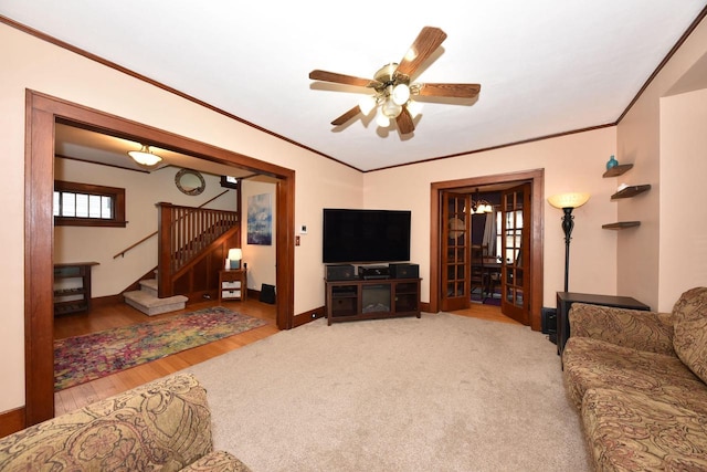 carpeted living room with ceiling fan and ornamental molding