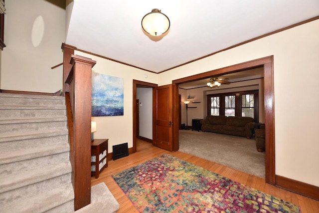 entrance foyer with ornamental molding and light hardwood / wood-style floors