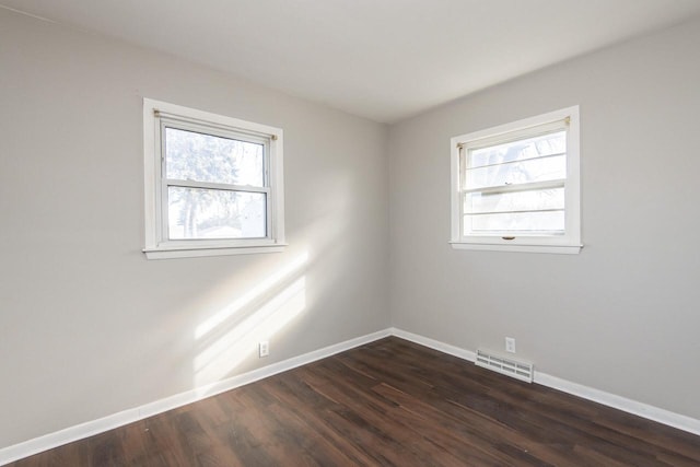 unfurnished room featuring plenty of natural light and dark hardwood / wood-style flooring