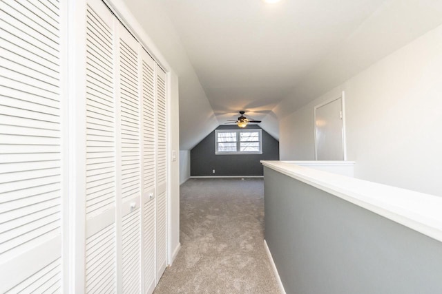 hall featuring dark colored carpet and vaulted ceiling