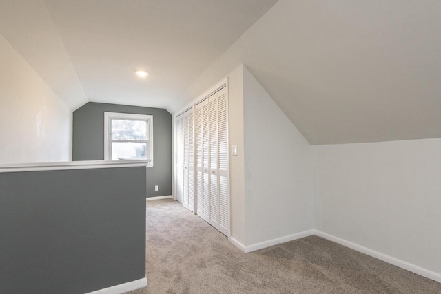 bonus room featuring vaulted ceiling and light colored carpet