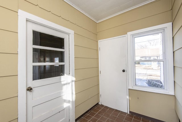 doorway featuring crown molding and wooden walls