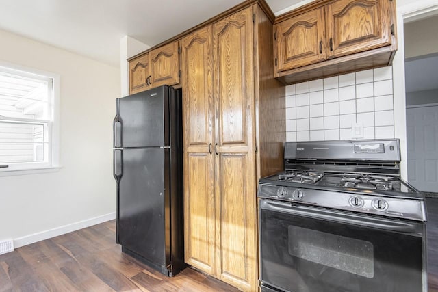 kitchen with tasteful backsplash, dark hardwood / wood-style flooring, and black appliances