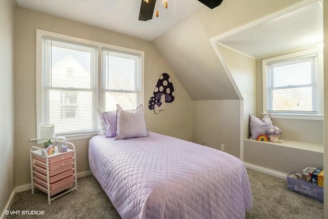 bedroom featuring multiple windows, vaulted ceiling, ceiling fan, and dark carpet